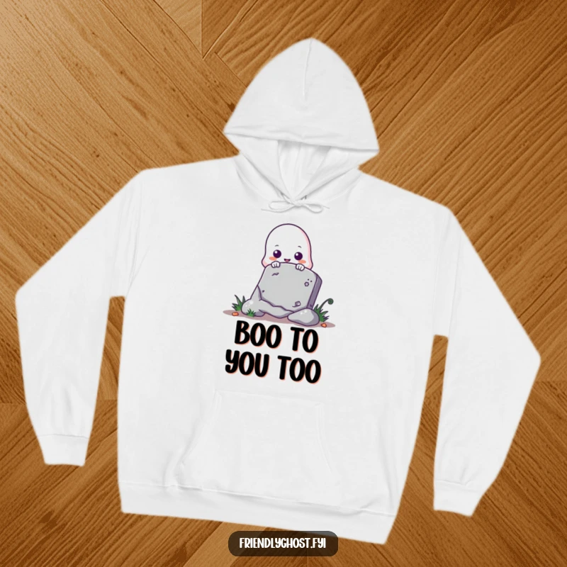 Funny ghost hoodie showing a cute ghost playfully peeking from behind a tombstone, ideal for a cozy Halloween.